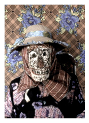 Skull-faced puppet wearing a straw hat.