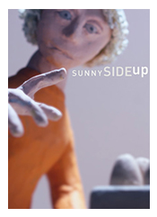 Puppet with light yellow curly hair, orange long-sleeve turtle neck, looking at it's fingers.